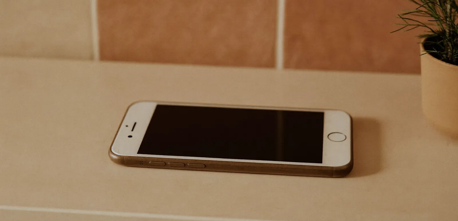 Smartphone op een salonbalie tegen een warme tegelwand