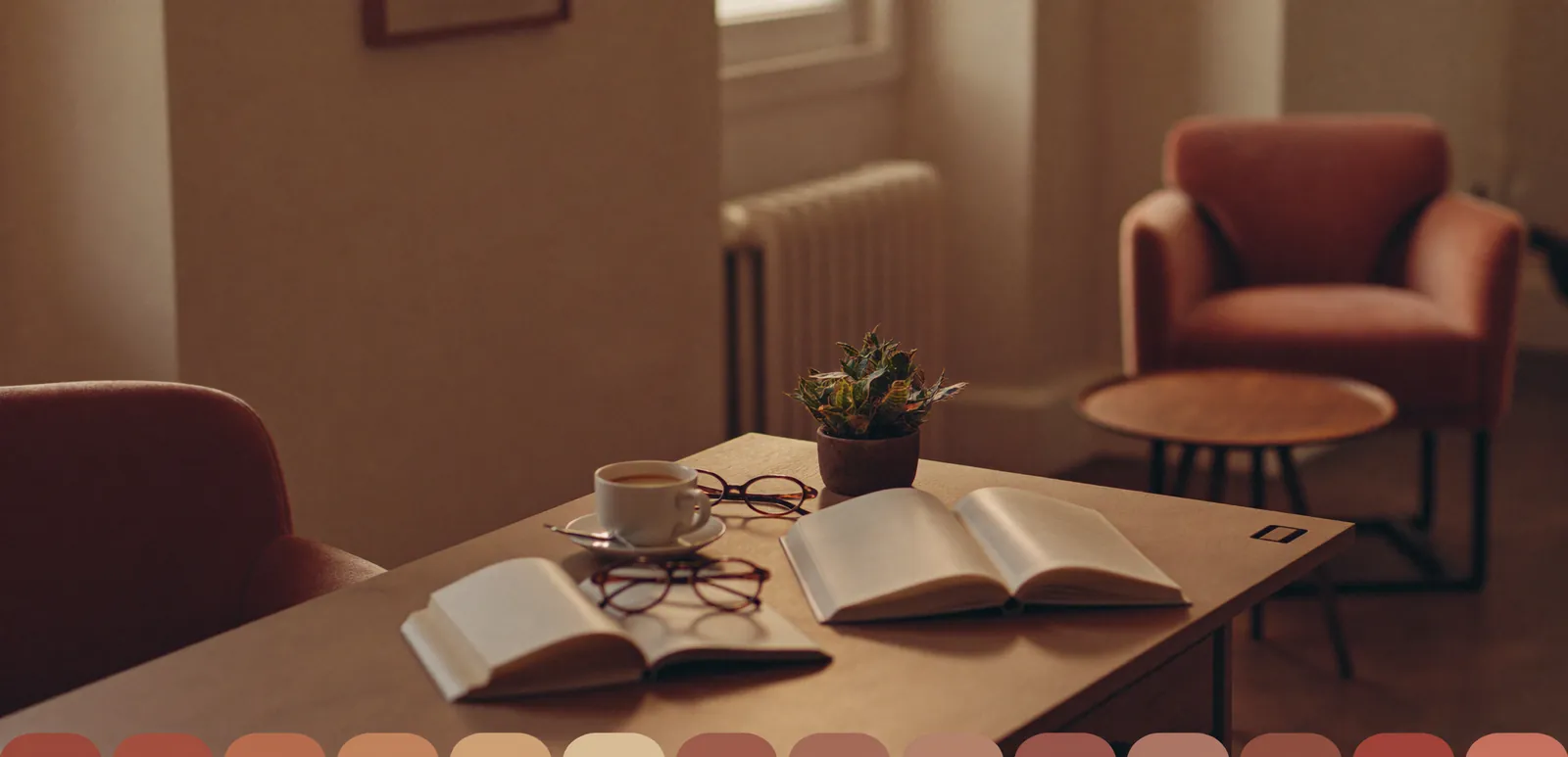 Open notitieboeken, een kopje koffie en een leesbril op een tafel in een salonlounge